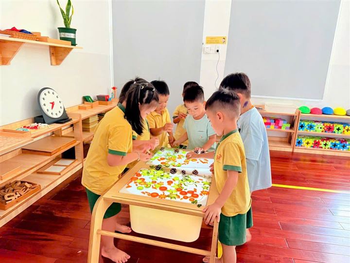 Nhóm bé quanh bàn giác quan trong lớp