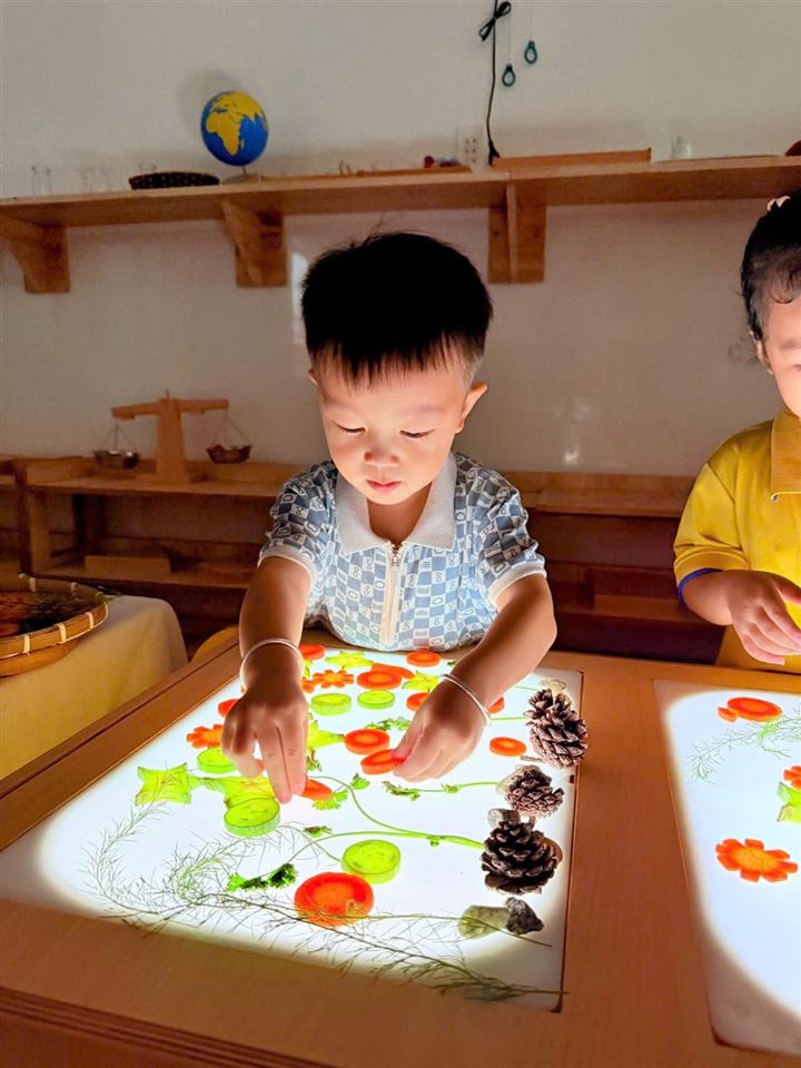 Bé xếp hình trên bàn ánh sáng