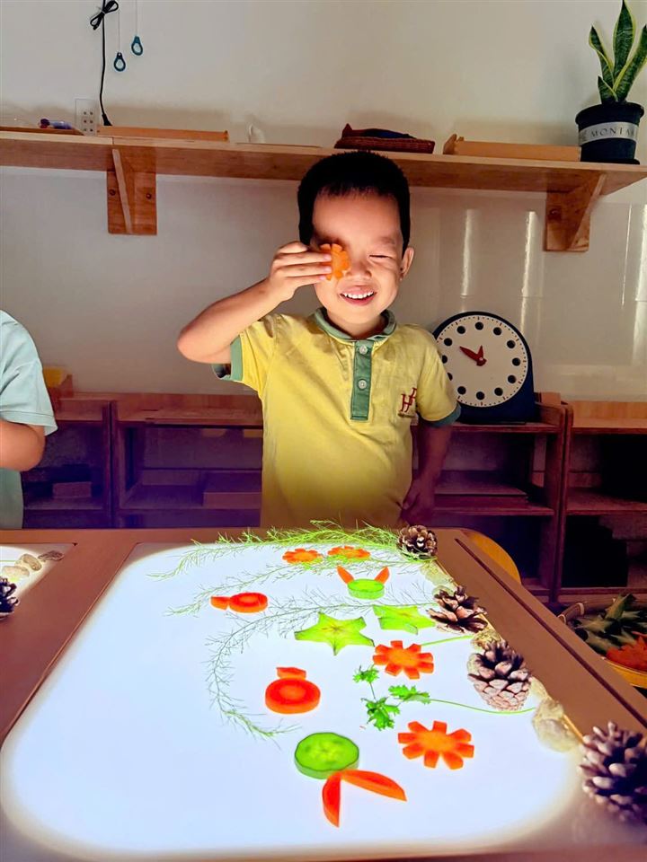 Bé cười khi chơi với bàn ánh sáng